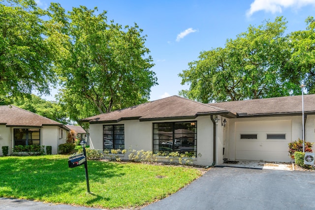 4731 Storkwood Ln Unit A, Boynton Beach, FL 33436 - view of front of house featuring stucco siding, driveway, a garage, and a front lawn