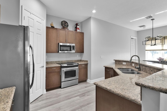 14841 Strand Ln (), Unit Delray Beach, FL 33446 - kitchen with stainless steel appliances, a sink, light wood-style floors, a chandelier, and decorative light fixtures