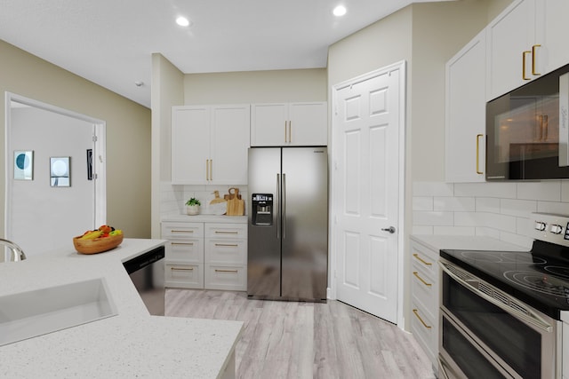 14841 Strand Ln (), Unit Delray Beach, FL 33446 - kitchen with appliances with stainless steel finishes, white cabinets, light wood-style floors, a sink, and recessed lighting
