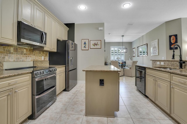 4884 SW Gossamer Cir, Palm City, FL 34990 - kitchen with appliances with stainless steel finishes, cream cabinets, a sink, a center island, and tasteful backsplash