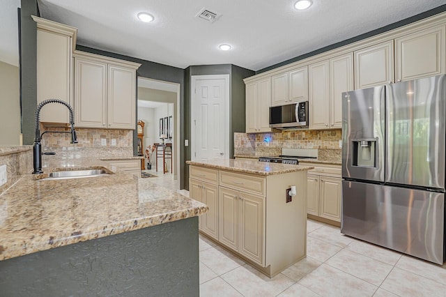 4884 SW Gossamer Cir, Palm City, FL 34990 - kitchen featuring stainless steel appliances, cream cabinets, a sink, and recessed lighting