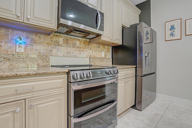 4884 SW Gossamer Cir, Palm City, FL 34990 - kitchen featuring stainless steel appliances, baseboards, light tile patterned floors, backsplash, and light stone counters