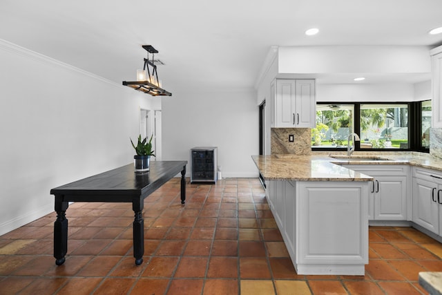 1318 NW 4th St, Boca Raton, FL 33486 - kitchen featuring a peninsula, wine cooler, decorative backsplash, white cabinets, and crown molding