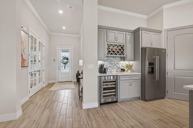 11620 Sally Ann Dr, Palm Beach Gardens, FL 33412 - kitchen with high end refrigerator, wine cooler, gray cabinetry, light wood-type flooring, and crown molding