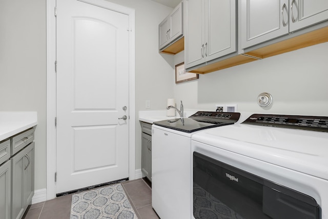 11620 Sally Ann Dr, Palm Beach Gardens, FL 33412 - washroom with separate washer and dryer, cabinet space, tile patterned flooring, and baseboards