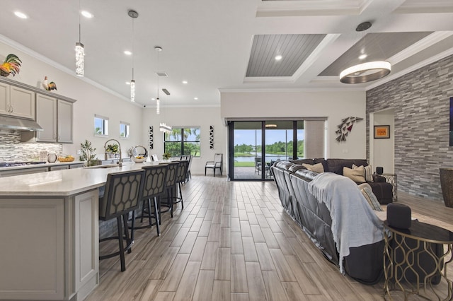 11620 Sally Ann Dr, Palm Beach Gardens, FL 33412 - kitchen featuring open floor plan, light countertops, gray cabinets, a sink, and a breakfast bar