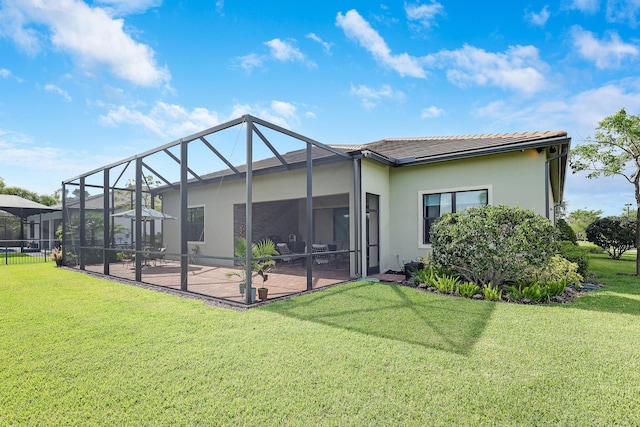 11620 Sally Ann Dr, Palm Beach Gardens, FL 33412 - back of house with a patio, a yard, stucco siding, and glass enclosure