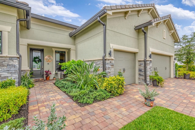 11620 Sally Ann Dr, Palm Beach Gardens, FL 33412 - view of front facade with stone siding, a garage, and stucco siding