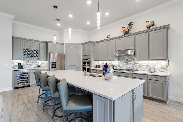 11620 Sally Ann Dr, Palm Beach Gardens, FL 33412 - kitchen with gray cabinetry, beverage cooler, appliances with stainless steel finishes, under cabinet range hood, and a sink