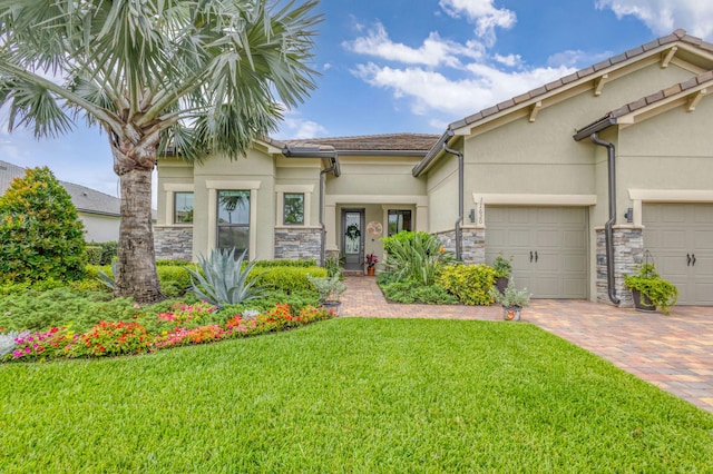 11620 Sally Ann Dr, Palm Beach Gardens, FL 33412 - view of front of house with stucco siding, a front lawn, stone siding, a garage, and decorative driveway