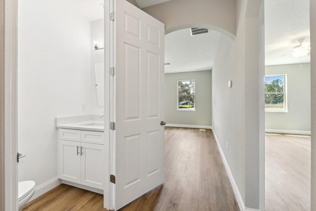 518 Scodella St SW, Palm Bay, FL 32908 - corridor with arched walkways, light wood-style flooring, plenty of natural light, and baseboards