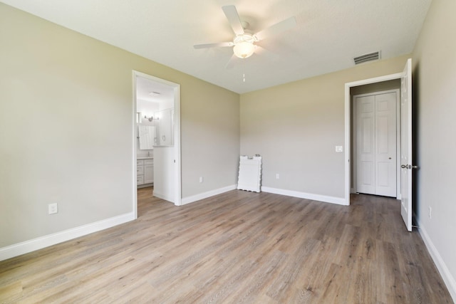 518 Scodella St SW, Palm Bay, FL 32908 - unfurnished bedroom with light wood-type flooring, baseboards, connected bathroom, and a ceiling fan