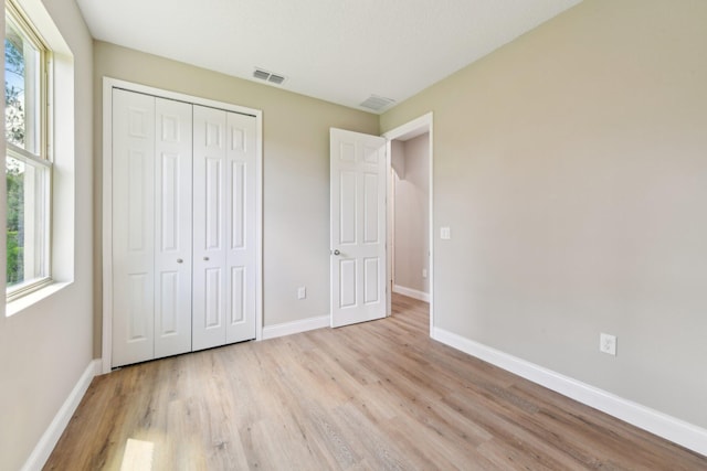 518 Scodella St SW, Palm Bay, FL 32908 - unfurnished bedroom with light wood finished floors, baseboards, and a closet