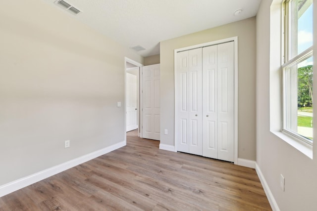 518 Scodella St SW, Palm Bay, FL 32908 - unfurnished bedroom with light wood finished floors, baseboards, and a closet