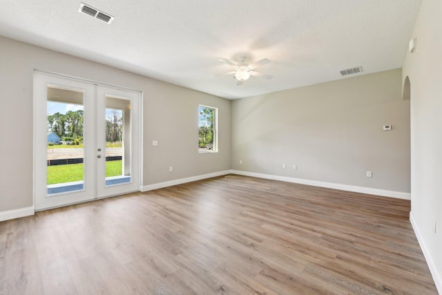 518 Scodella St SW, Palm Bay, FL 32908 - unfurnished room with ceiling fan, arched walkways, baseboards, wood finished floors, and french doors