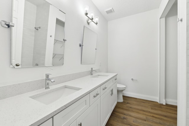518 Scodella St SW, Palm Bay, FL 32908 - bathroom featuring toilet, double vanity, wood finished floors, a tile shower, and baseboards
