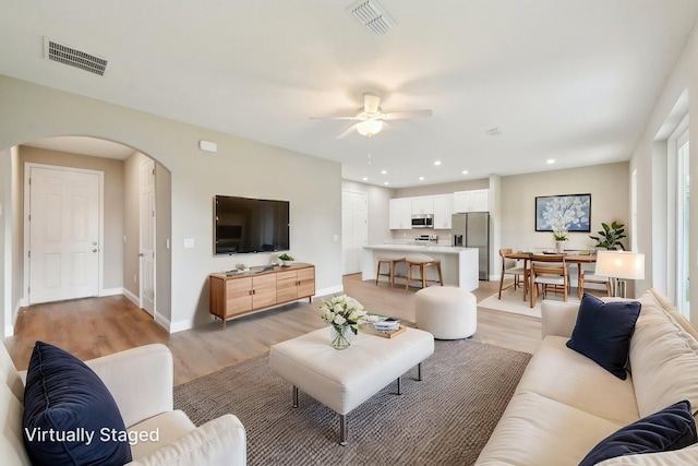 518 Scodella St SW, Palm Bay, FL 32908 - living area featuring arched walkways, a ceiling fan, light wood finished floors, baseboards, and recessed lighting