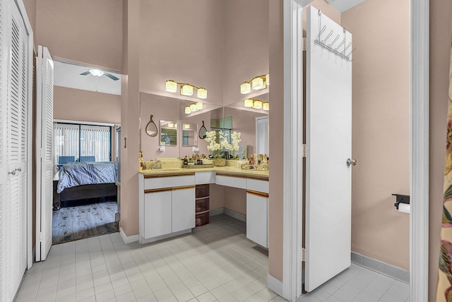5830 Parkwalk Cir W, Boynton Beach, FL 33472 - bathroom with vanity, a ceiling fan, tile patterned flooring, baseboards, and a towering ceiling