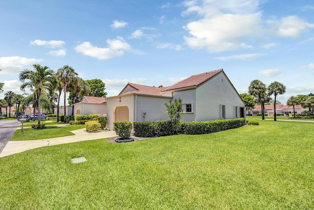 5830 Parkwalk Cir W, Boynton Beach, FL 33472 - view of side of property with concrete driveway, a tile roof, stucco siding, and a yard