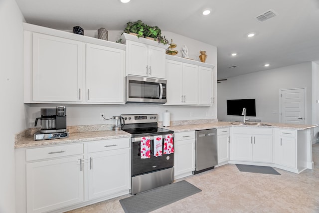 5309 Vespera St, Fort Pierce, FL 34951 - kitchen featuring appliances with stainless steel finishes, white cabinets, a peninsula, a sink, and recessed lighting