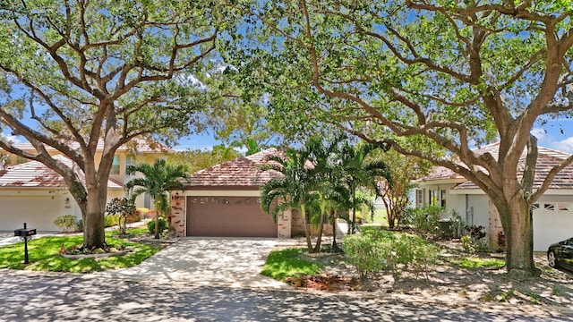 4560 Sherwood Forest Dr, Delray Beach, FL 33445 - view of front of property with an attached garage, brick siding, and driveway