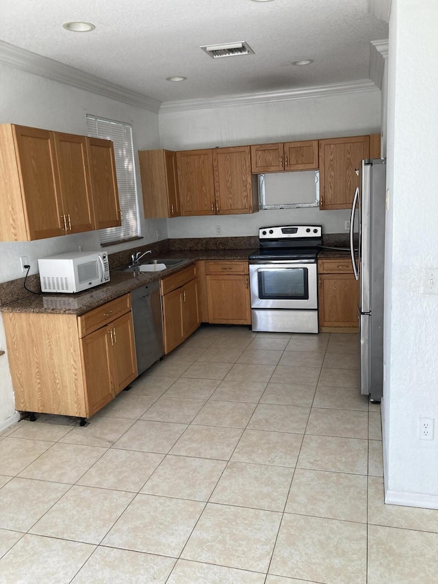 1098 Winding Rose Way, West Palm Beach, FL 33415 - kitchen with appliances with stainless steel finishes, ornamental molding, brown cabinetry, dark countertops, and a sink