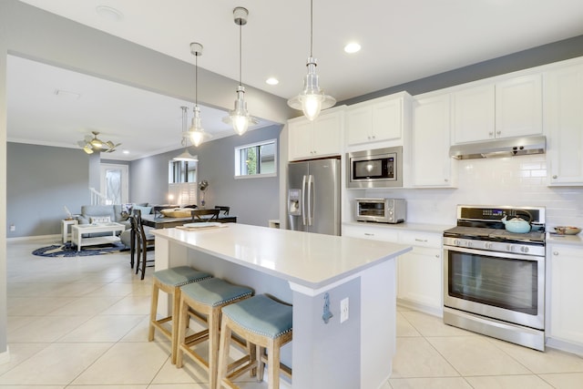568 SE Monet Dr, Port Saint Lucie, FL 34984 - kitchen with appliances with stainless steel finishes, under cabinet range hood, decorative backsplash, light countertops, and recessed lighting