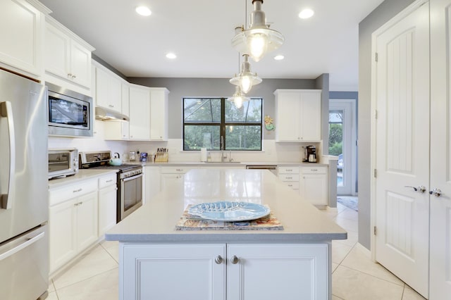 568 SE Monet Dr, Port Saint Lucie, FL 34984 - kitchen with stainless steel appliances, under cabinet range hood, plenty of natural light, a sink, and recessed lighting