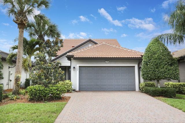 568 SE Monet Dr, Port Saint Lucie, FL 34984 - view of front of property with driveway, a garage, stucco siding, and a tiled roof
