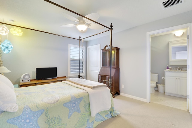 568 SE Monet Dr, Port Saint Lucie, FL 34984 - bedroom featuring a sink, ensuite bathroom, light colored carpet, baseboards, and a ceiling fan