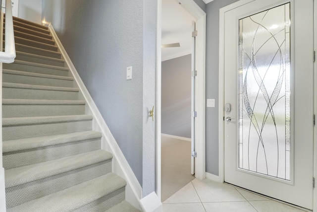 568 SE Monet Dr, Port Saint Lucie, FL 34984 - foyer featuring stairs, light tile patterned floors, baseboards, crown molding, and a textured wall
