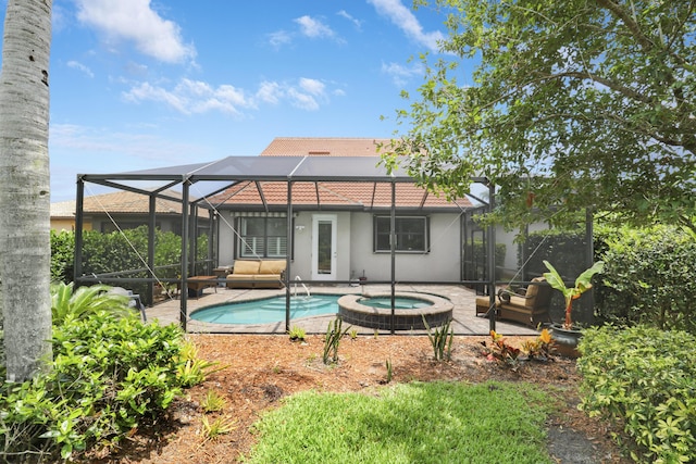 568 SE Monet Dr, Port Saint Lucie, FL 34984 - rear view of property featuring an in-ground hot tub, a patio, stucco siding, and glass enclosure