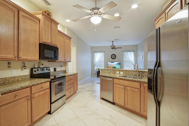 697 SW Dairy Rd, Port Saint Lucie, FL 34953 - kitchen with stainless steel appliances, a sink, a ceiling fan, light stone counters, and a peninsula