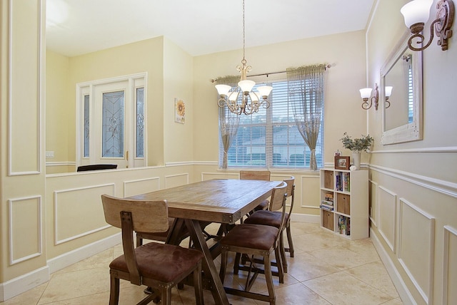 697 SW Dairy Rd, Port Saint Lucie, FL 34953 - dining space featuring a decorative wall, a chandelier, a wainscoted wall, and light tile patterned floors