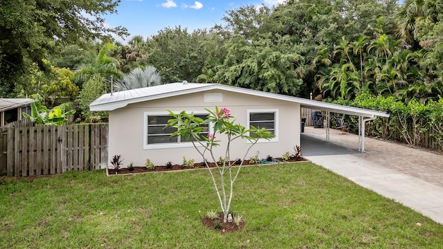 709 SW Bryant Ave, Stuart, FL 34994 - ranch-style home featuring driveway, a carport, and stucco siding