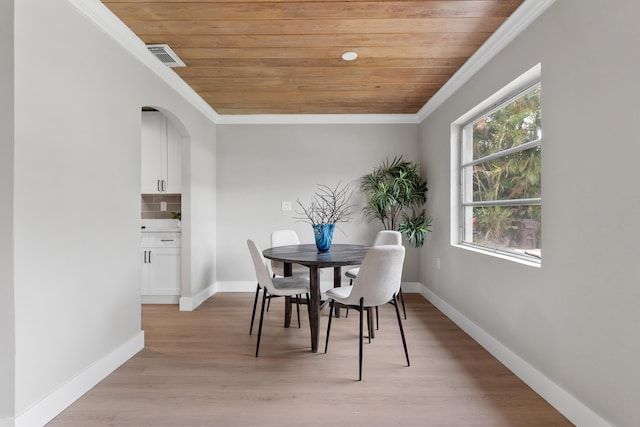 709 SW Bryant Ave, Stuart, FL 34994 - dining room with wooden ceiling, crown molding, baseboards, light wood-type flooring, and arched walkways