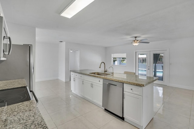 6650 NW 22nd Ct, Margate, FL 33063 - kitchen with stainless steel appliances, a sink, white cabinetry, light stone countertops, and light tile patterned flooring