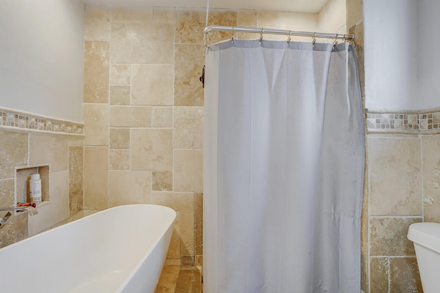 6650 NW 22nd Ct, Margate, FL 33063 - bathroom featuring tile walls, toilet, a freestanding tub, and a shower with curtain