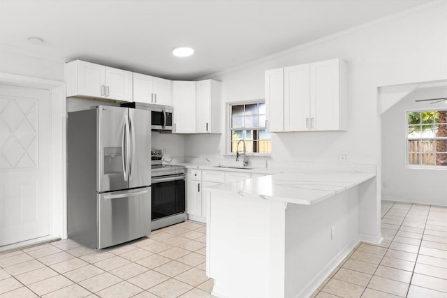 7802 Miramar Ave, Fort Pierce, FL 34951 - kitchen featuring stainless steel appliances, a sink, a peninsula, light countertops, and light tile patterned floors