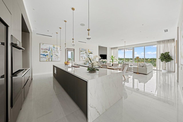 246 NE 6th Ave Unit Ph1, Delray Beach, FL 33483 - kitchen with modern cabinets, a sink, open floor plan, a large island with sink, and decorative light fixtures