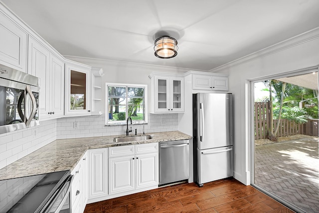 2934 SW 22nd Cir Unit 12A, Delray Beach, FL 33445 - kitchen with stainless steel appliances, crown molding, light stone counters, white cabinetry, and glass insert cabinets