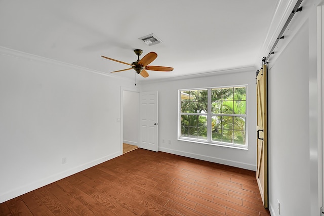 2934 SW 22nd Cir Unit 12A, Delray Beach, FL 33445 - unfurnished room with a barn door, ornamental molding, ceiling fan, and wood finished floors