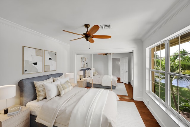 2934 SW 22nd Cir Unit 12A, Delray Beach, FL 33445 - bedroom featuring dark wood-type flooring, crown molding, a closet, and a ceiling fan
