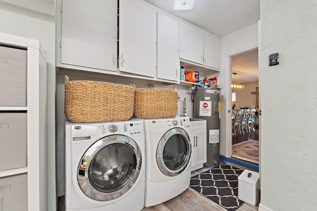 9674 Dogwood Ave, Palm Beach Gardens, FL 33410 - washroom with cabinet space, water heater, washer and dryer, wood finished floors, and a textured wall