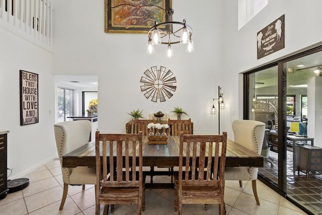 5625 Lakeview Mews Ct, Boynton Beach, FL 33437 - dining area with a towering ceiling, a chandelier, light tile patterned flooring, and baseboards