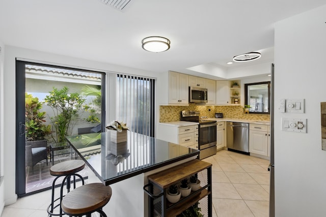 5625 Lakeview Mews Ct, Boynton Beach, FL 33437 - kitchen with stainless steel appliances, open shelves, a tray ceiling, light countertops, and tasteful backsplash