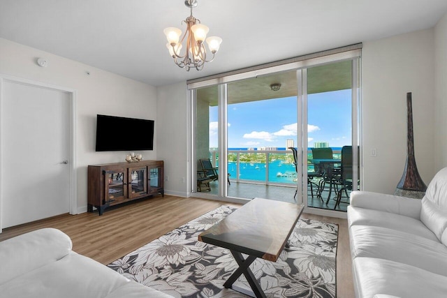 2640 Lake Shore Dr Unit 2409, Riviera Beach, FL 33404 - living room featuring a chandelier, light wood-type flooring, a wall of windows, and baseboards