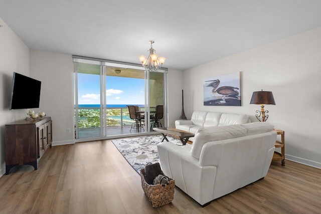 2640 Lake Shore Dr Unit 2409, Riviera Beach, FL 33404 - living room with a chandelier, wood finished floors, expansive windows, and baseboards