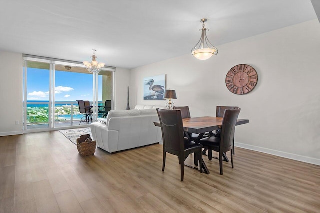 2640 Lake Shore Dr Unit 2409, Riviera Beach, FL 33404 - dining space with a chandelier, light wood finished floors, baseboards, and floor to ceiling windows