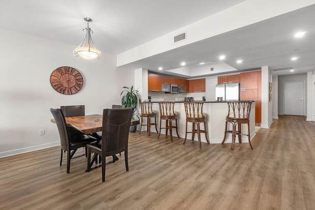 2640 Lake Shore Dr Unit 2409, Riviera Beach, FL 33404 - dining room featuring light wood-style floors, baseboards, recessed lighting, and a raised ceiling